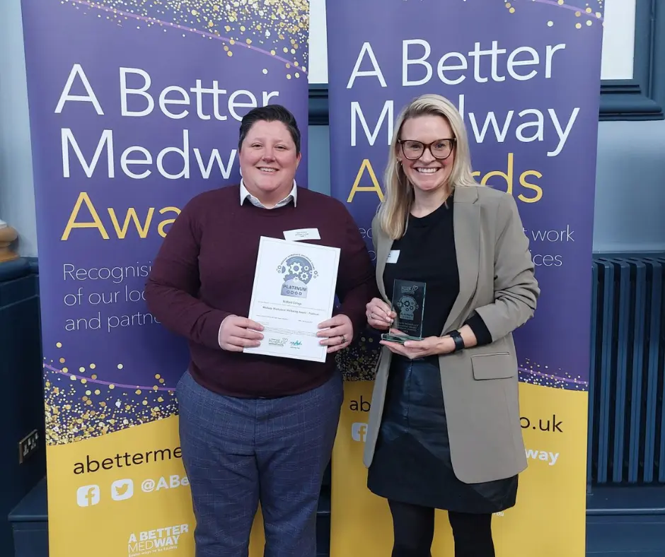 MidKent College staff collecting a certificate and trophy at the Healthy Workplace Awards